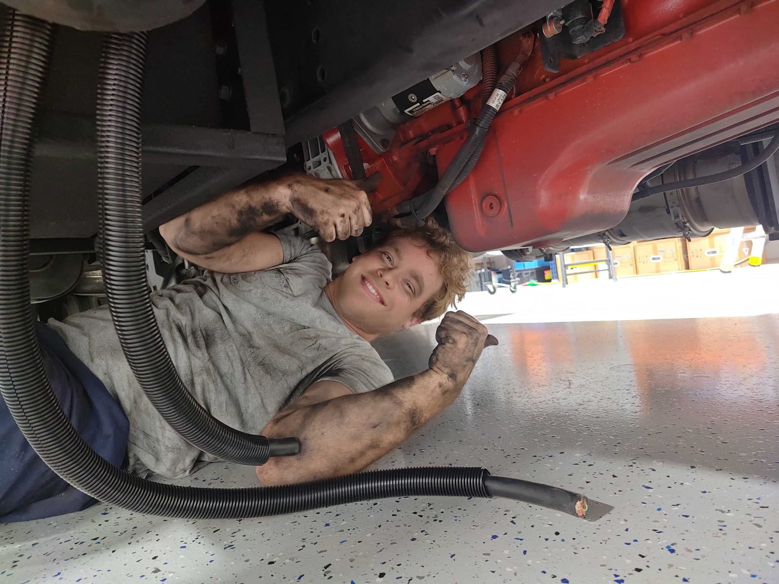 Technician lying under a truck routing cable through the frame